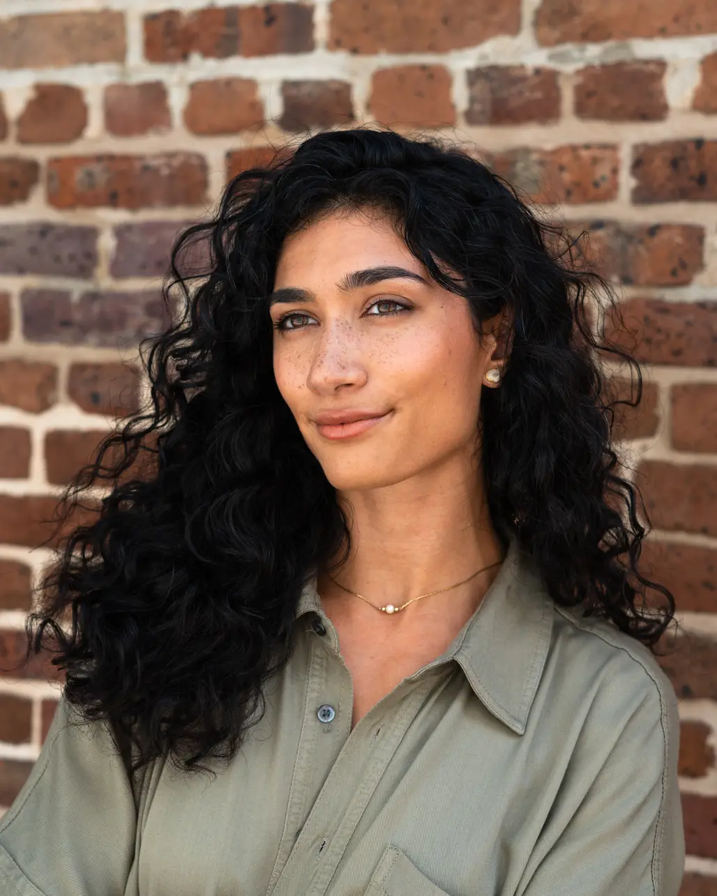 Portrait of Abby Fisher against a Charleston brick wall